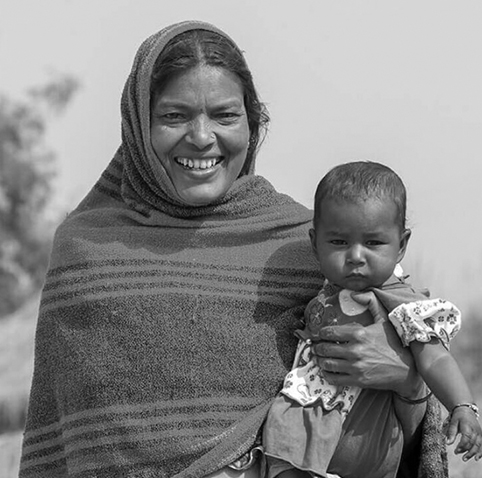 Mother and child in Village Chak Guru smiling near the water station